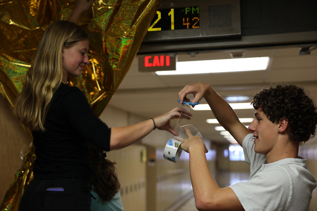 Students work together to hang hallway decor
