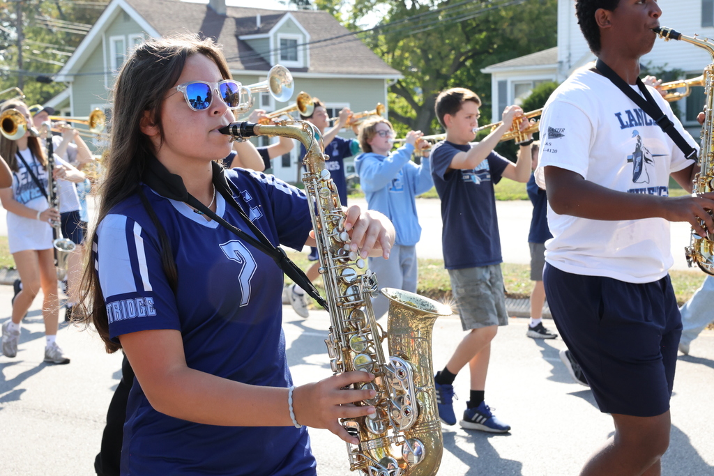 student walks with saxophone in parade