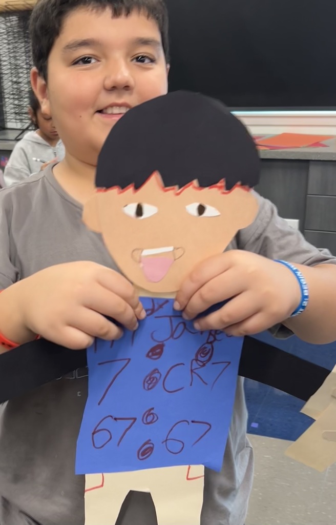 Student holds up self portrait