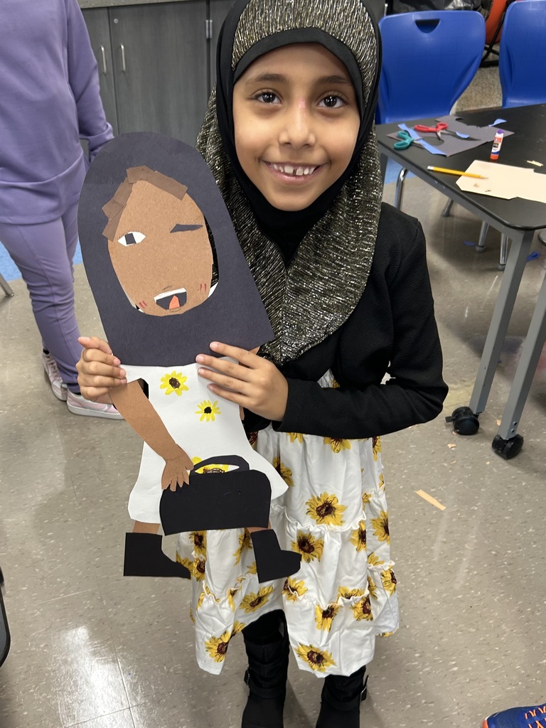 Student holds up self portrait