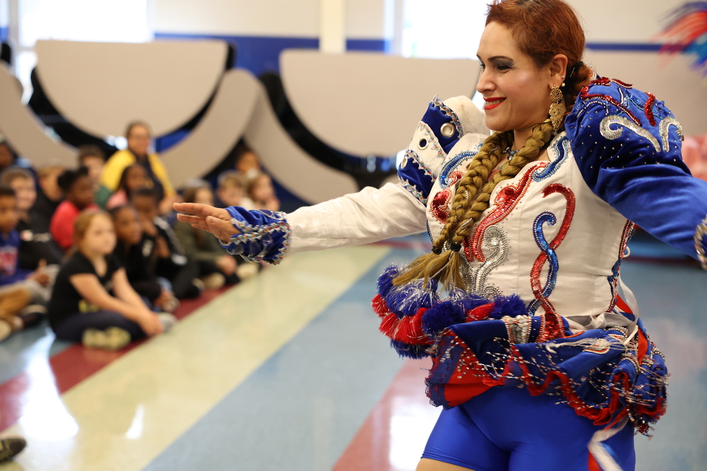 Performer wears traditional costume for a performance with students