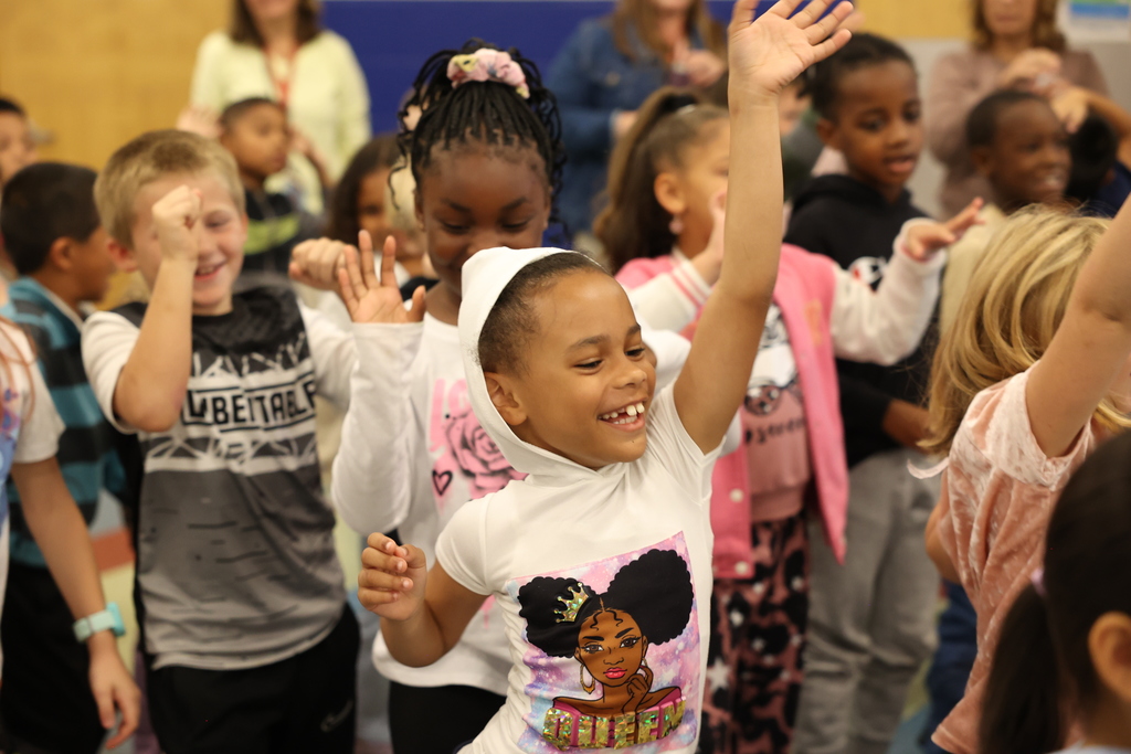 students dance during an assembly 