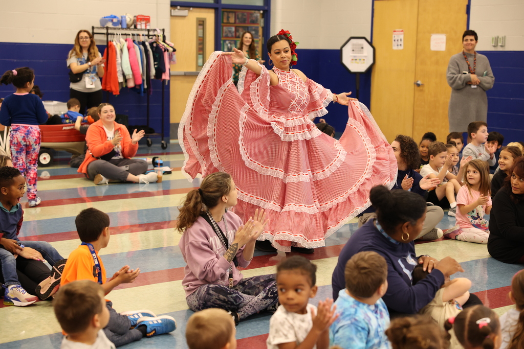 performer waves dress and dances with students