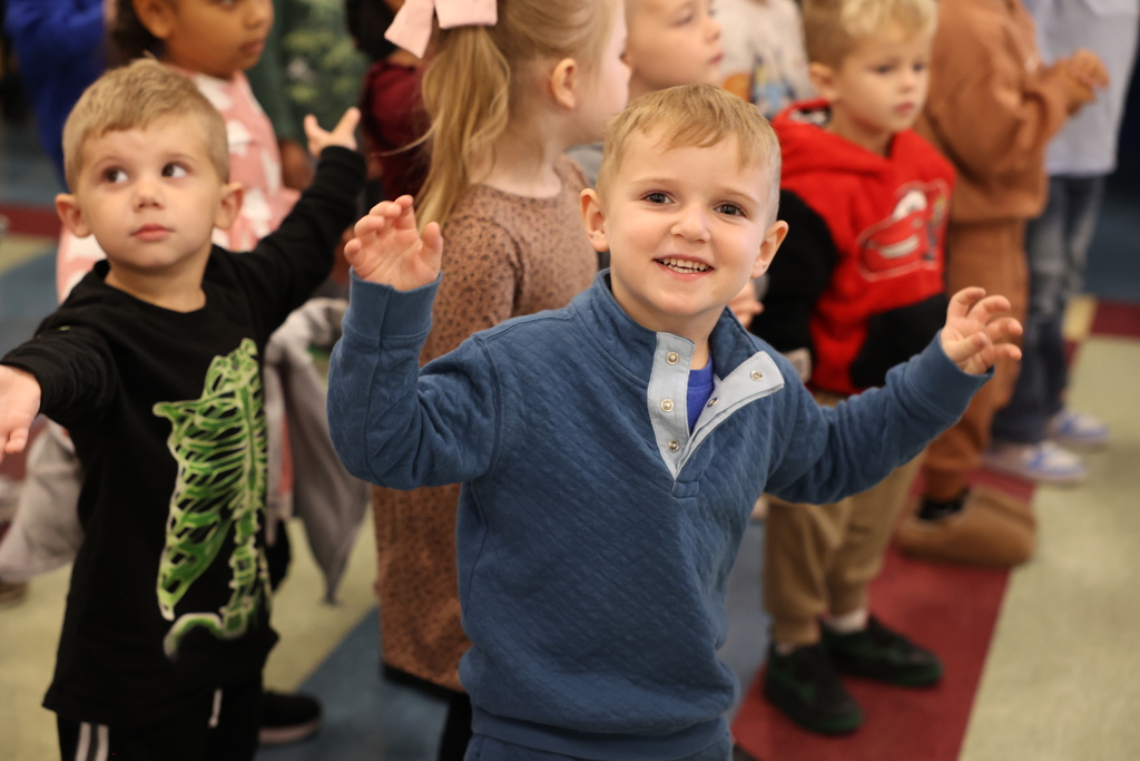 students dance during an assembly 