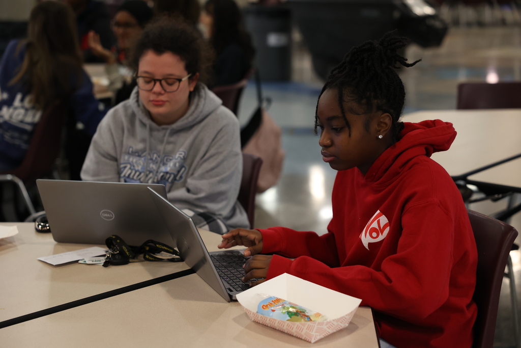 Two students look at laptop