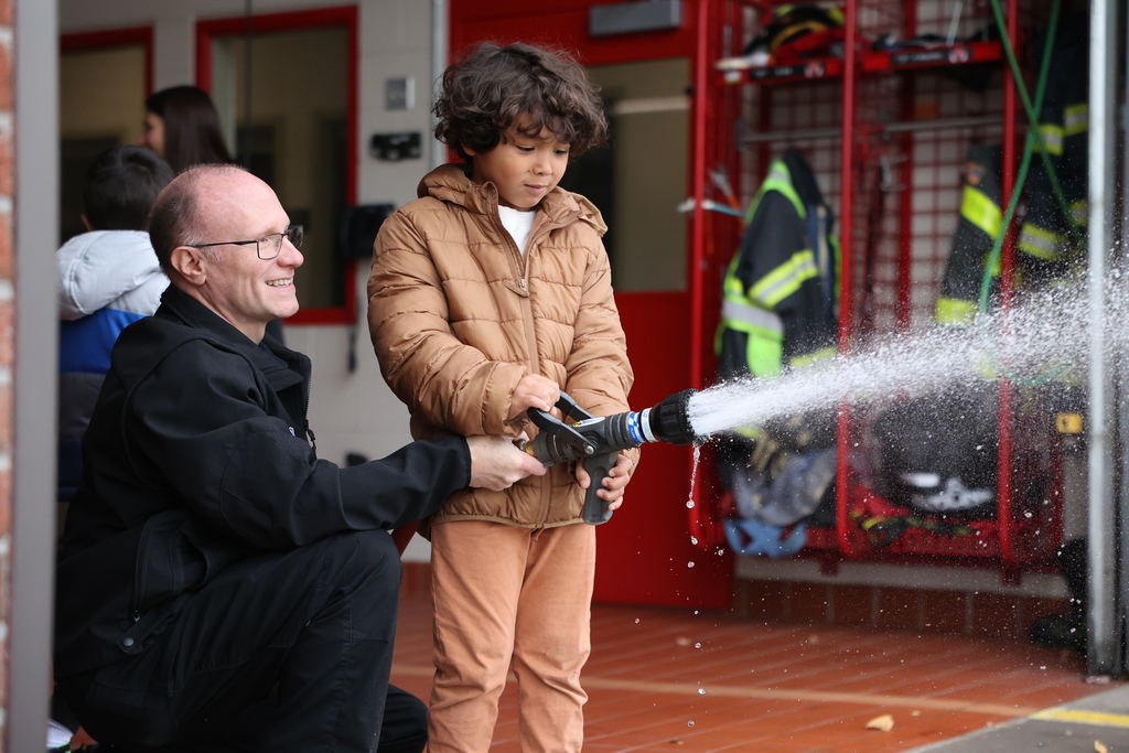 Student holds the hose with firefighter