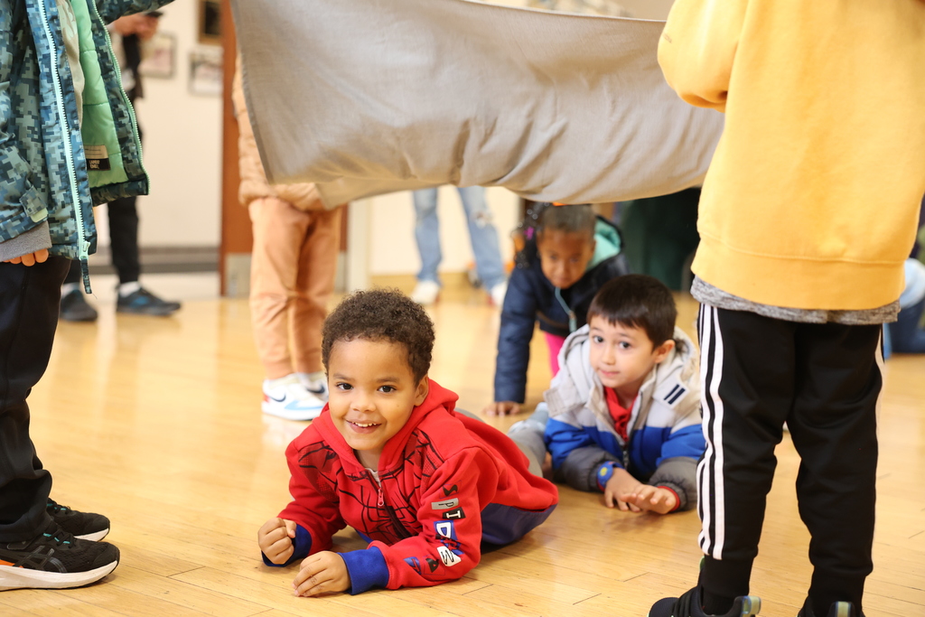 students crawl under sheet