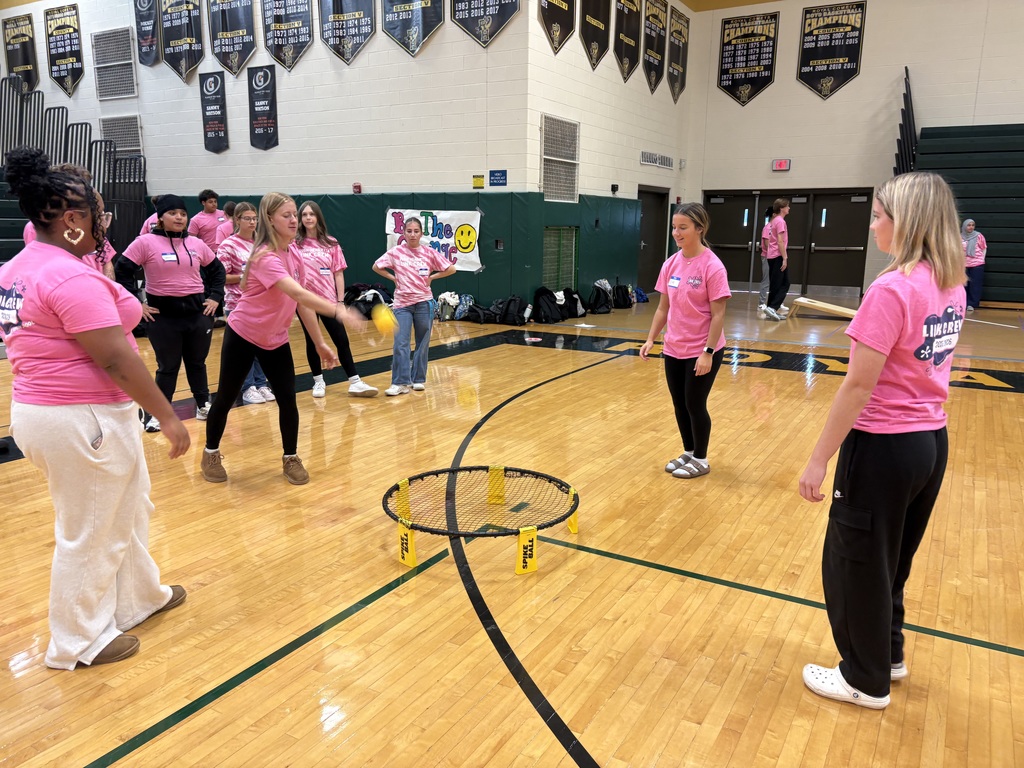 Students play game in the gymnasium with pink shirts on