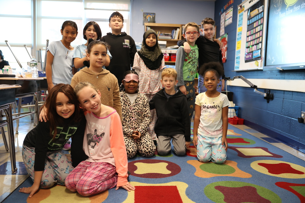 Students pose in their pjs in the classroom for a group pic