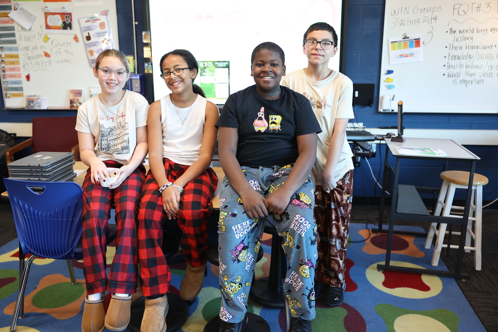 students sit on desk with pj pants on 