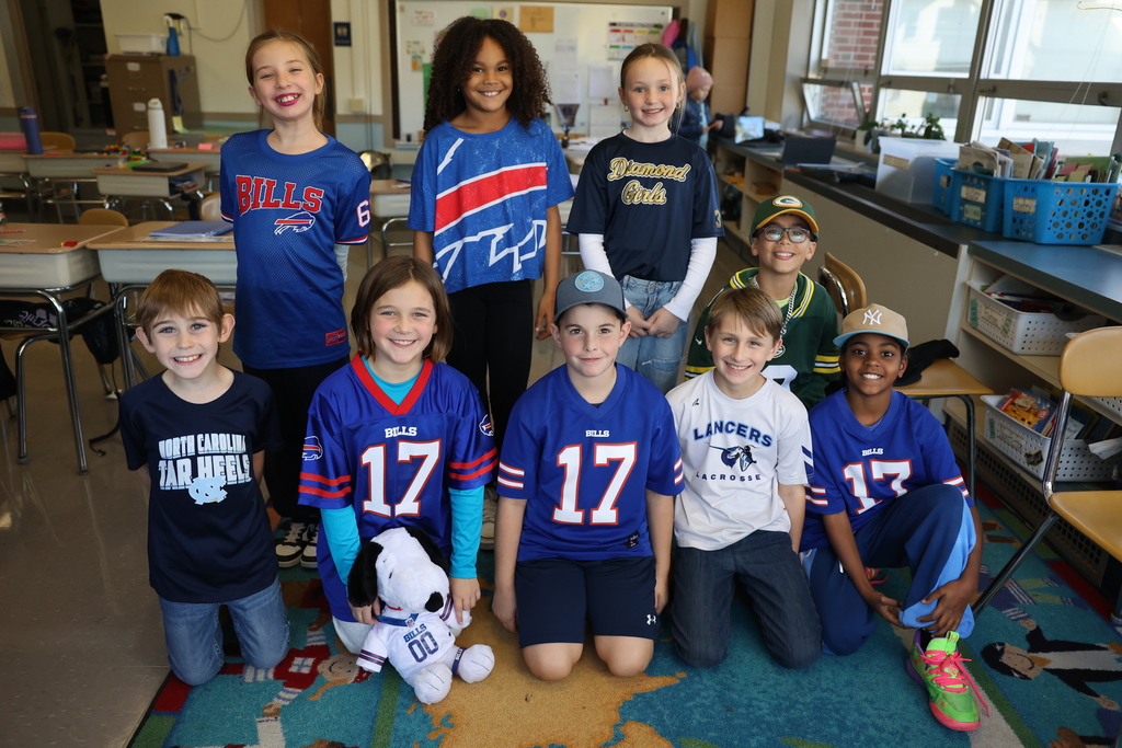 Student pose with jerseys in the classroom