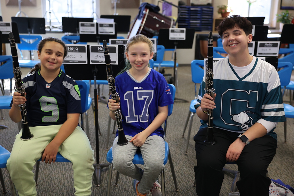 students hold clarinets and jerseys