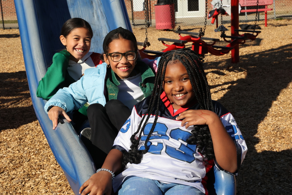 students pose on the slide in their jerseys