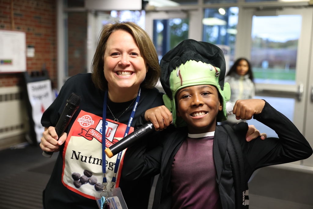 Student poses in costume with microphone