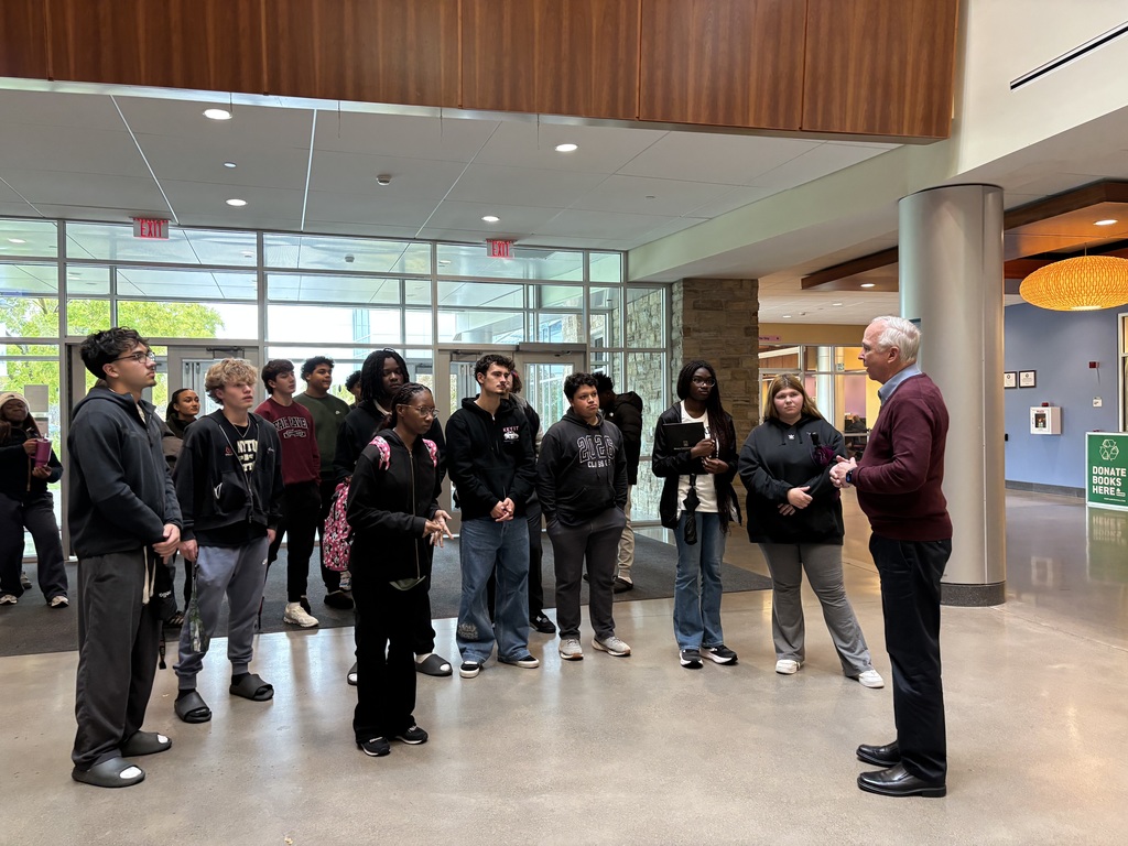 students listen to tour guide at schools