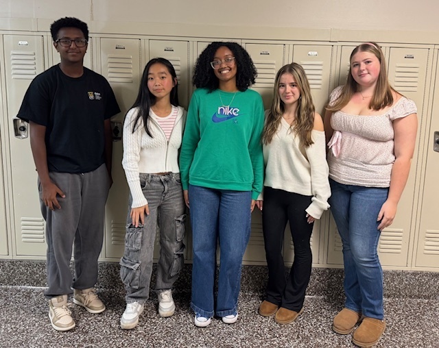 Students stand in front of lockers