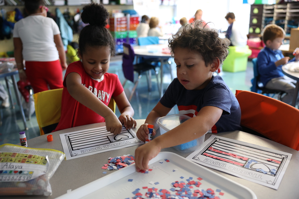 Students work on their veterans day cards pasting paper pieces 