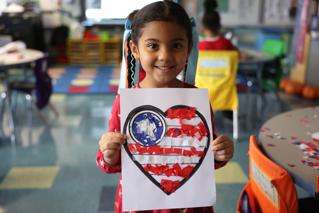 student holds up veterans day card