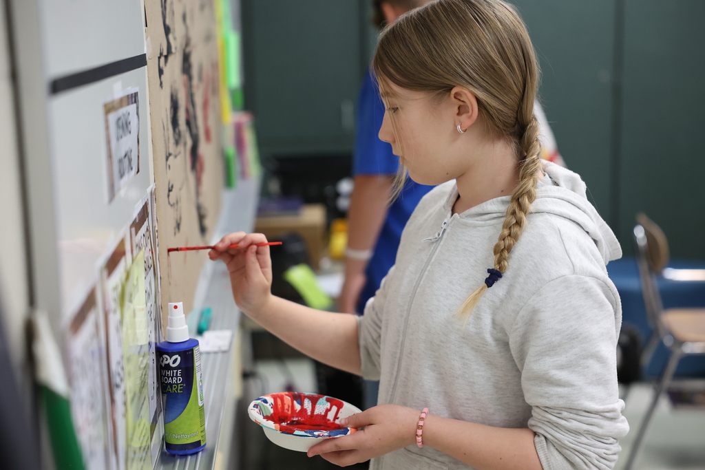 student paints on paper