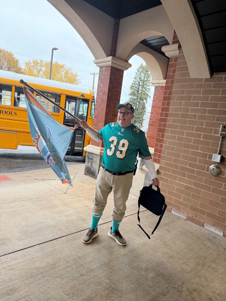 Mr Roach waving his Dolphin's flag during bus duty.