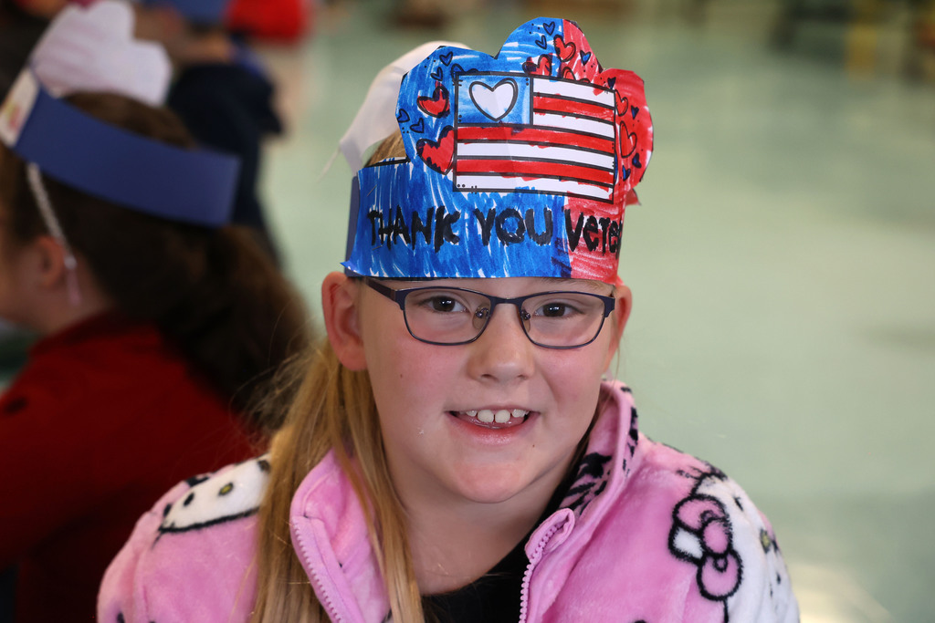 student smiles with thank you veterans hat
