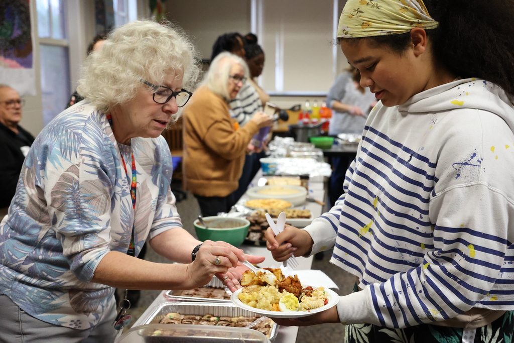 Student smiles while receiving food on plate