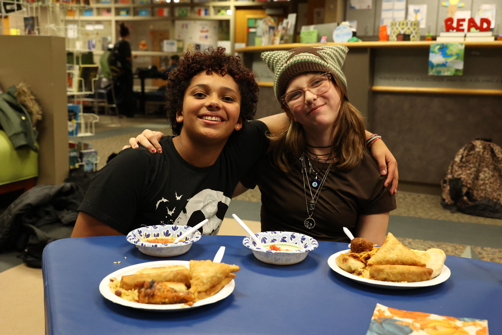 students smile with food in the library