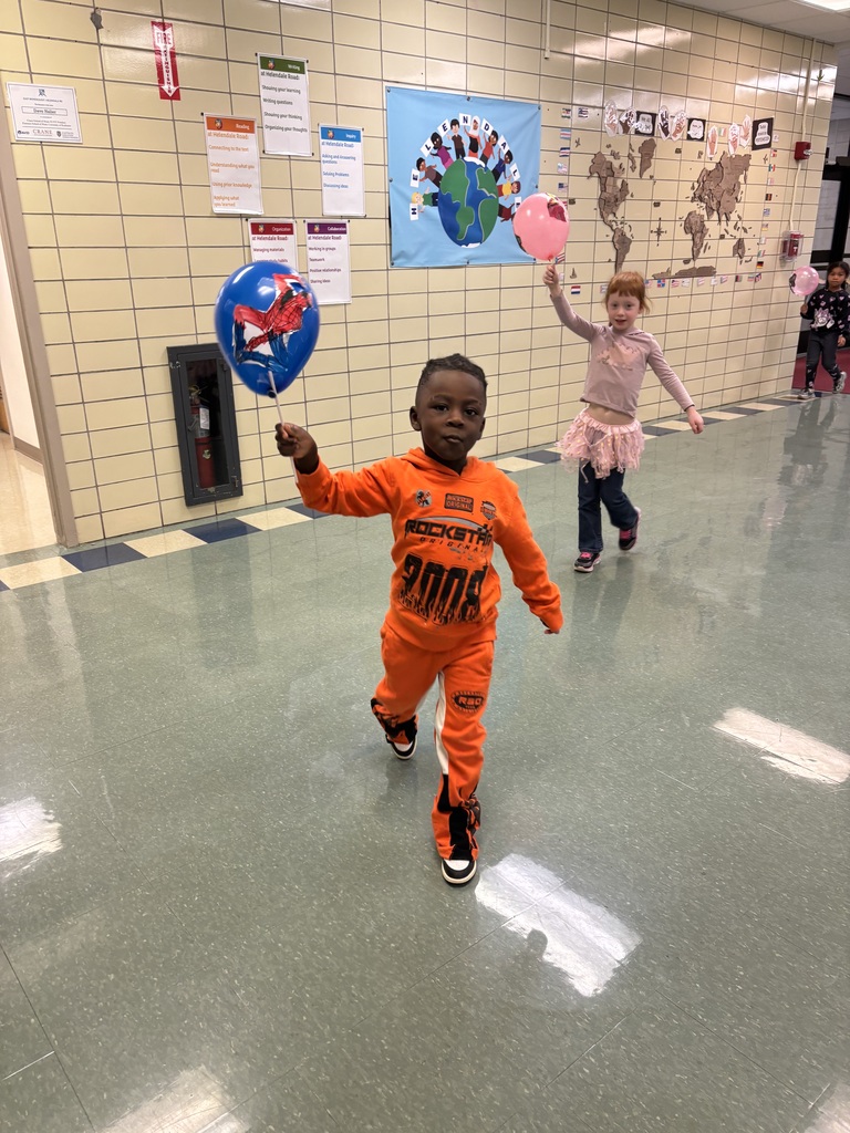Students hold up balloons for a Macys day inspired school parade