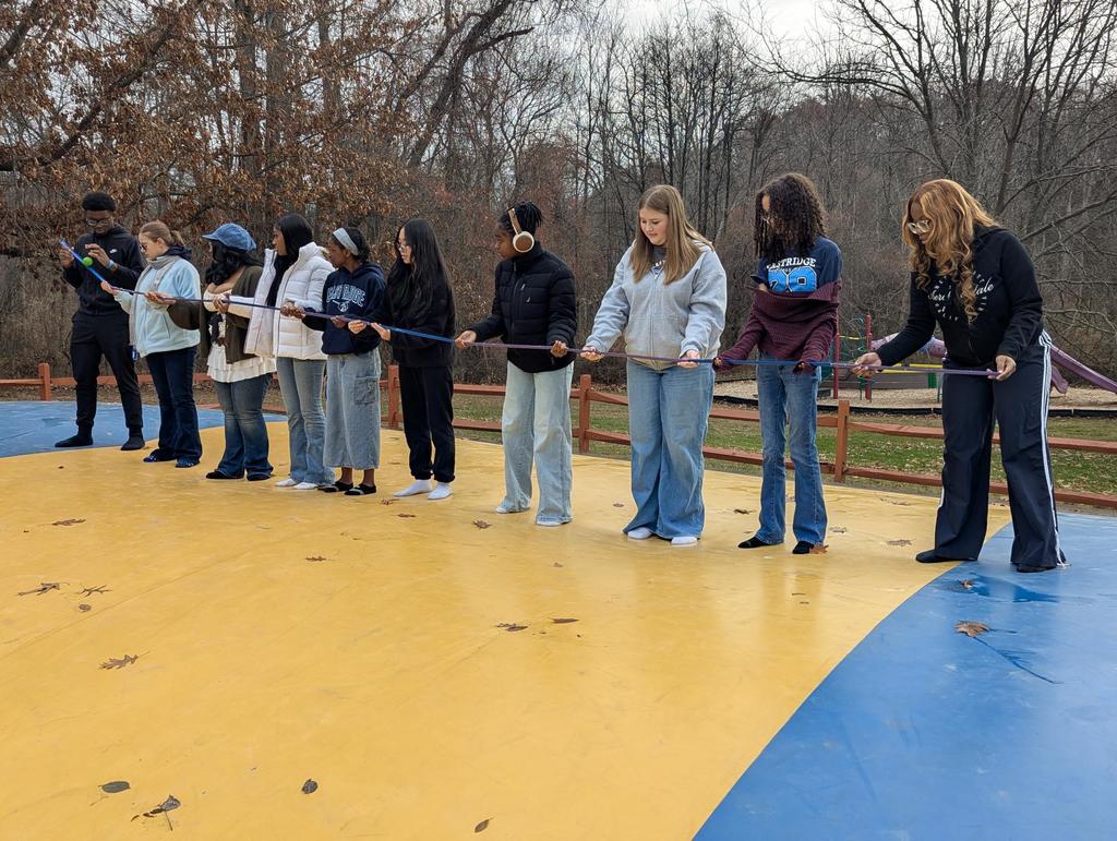 students work together to make ball go down chute