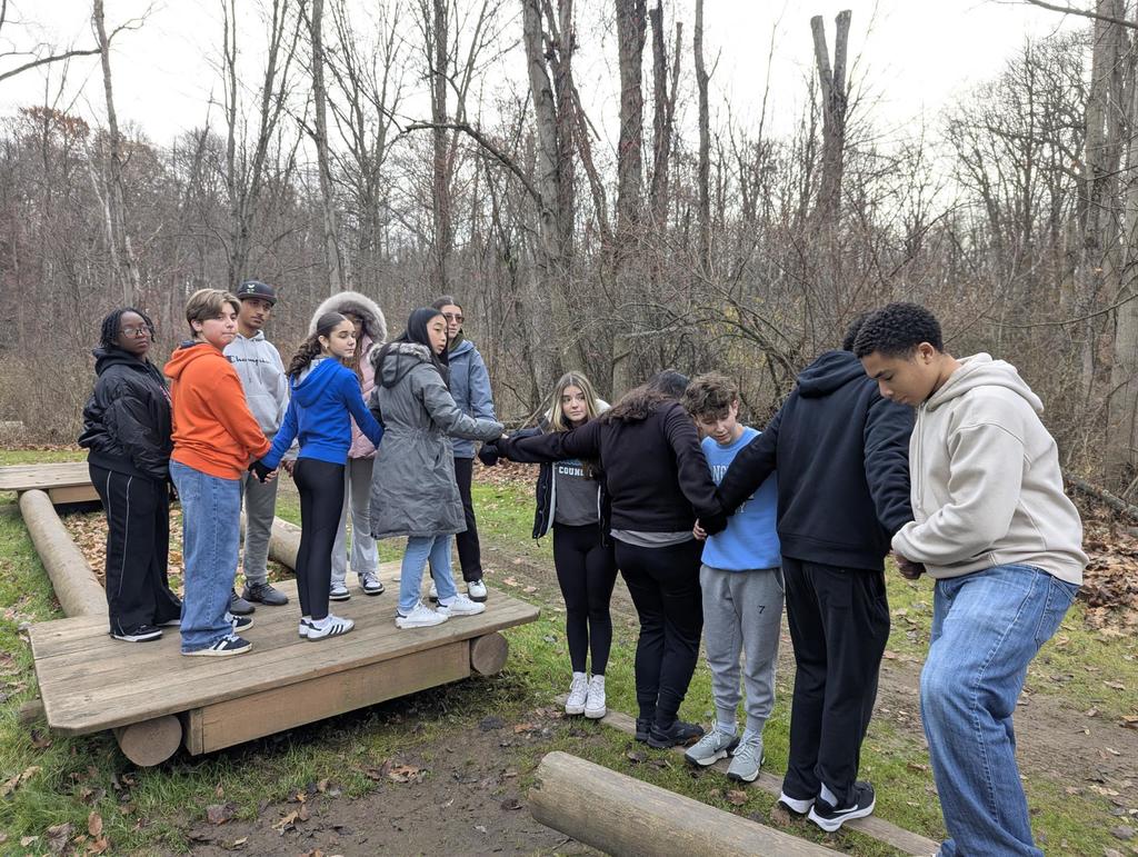 students hold hands on team building activity