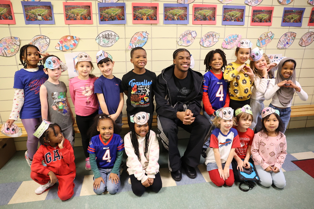 Ja'Marcus pose with students at Helendale in the hallway