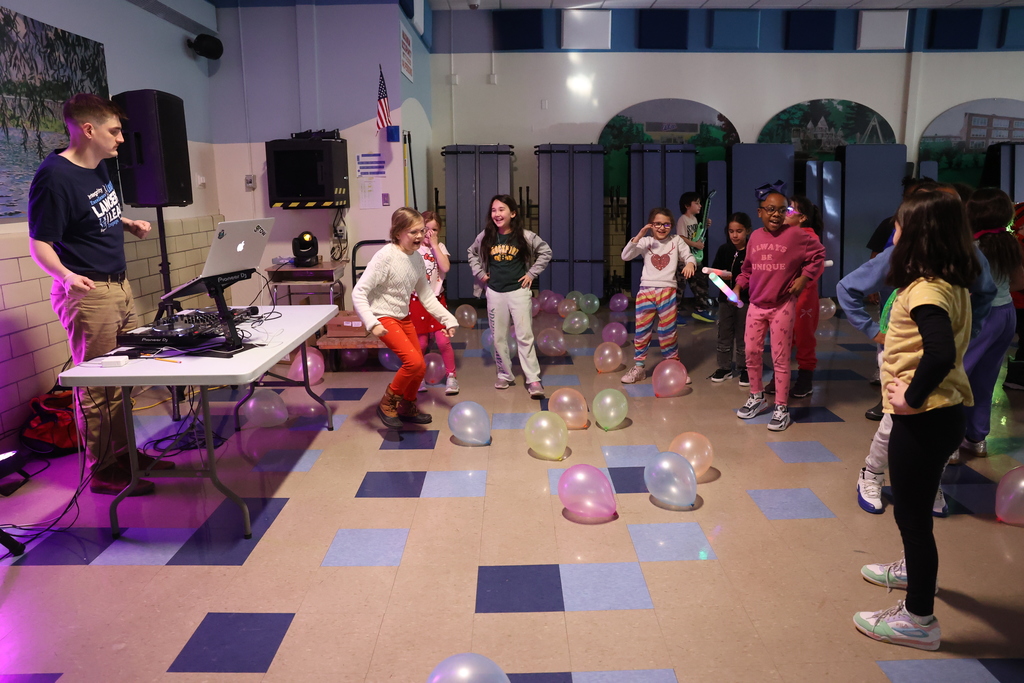 Students dance at dance party with balloons on the ground