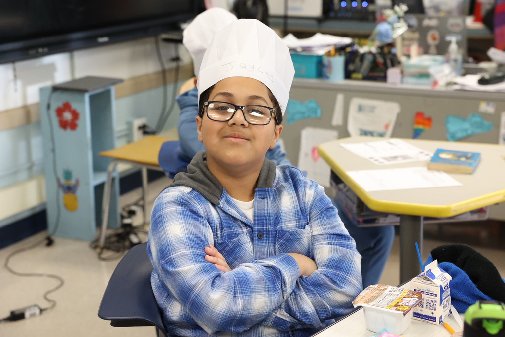 student strikes a pose with chef hat