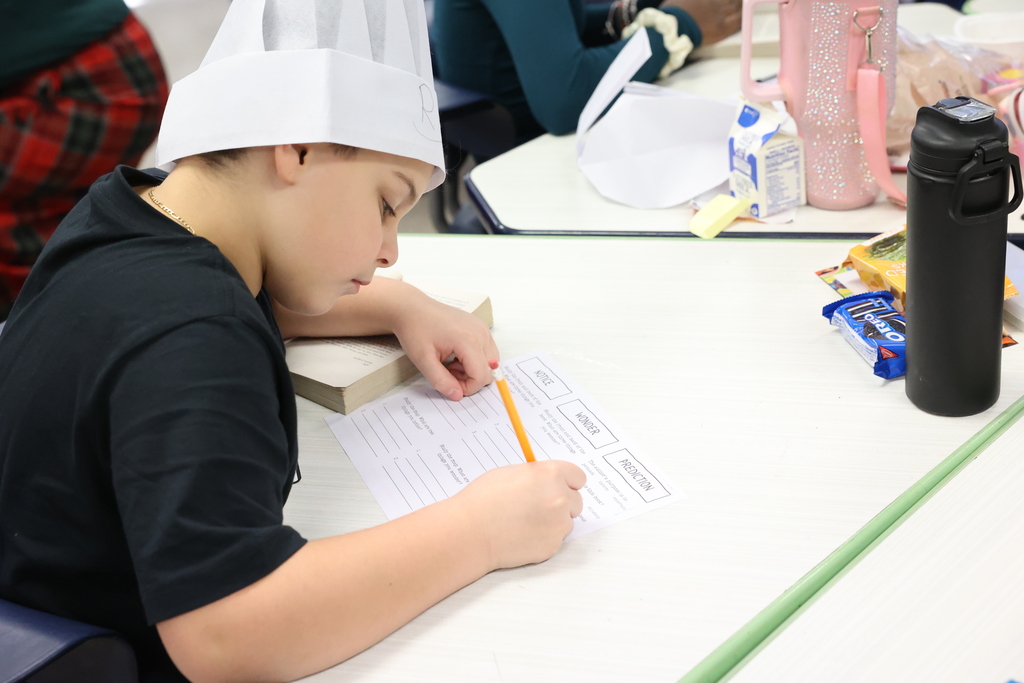 Student writes on paper with chef hat notice, wonder and prediction