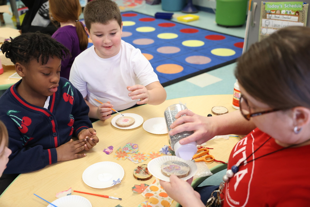 students work on ornaments with teacher