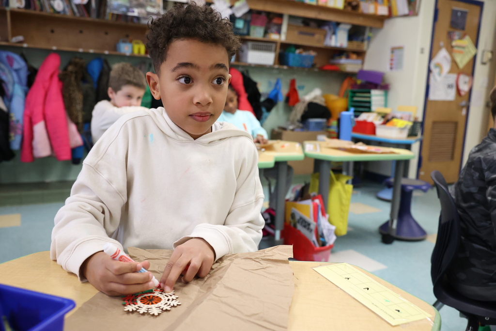 student works on coloring his snowflake ornament