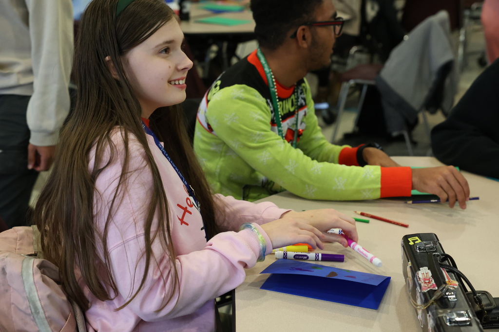 student smiles when using markers for a card