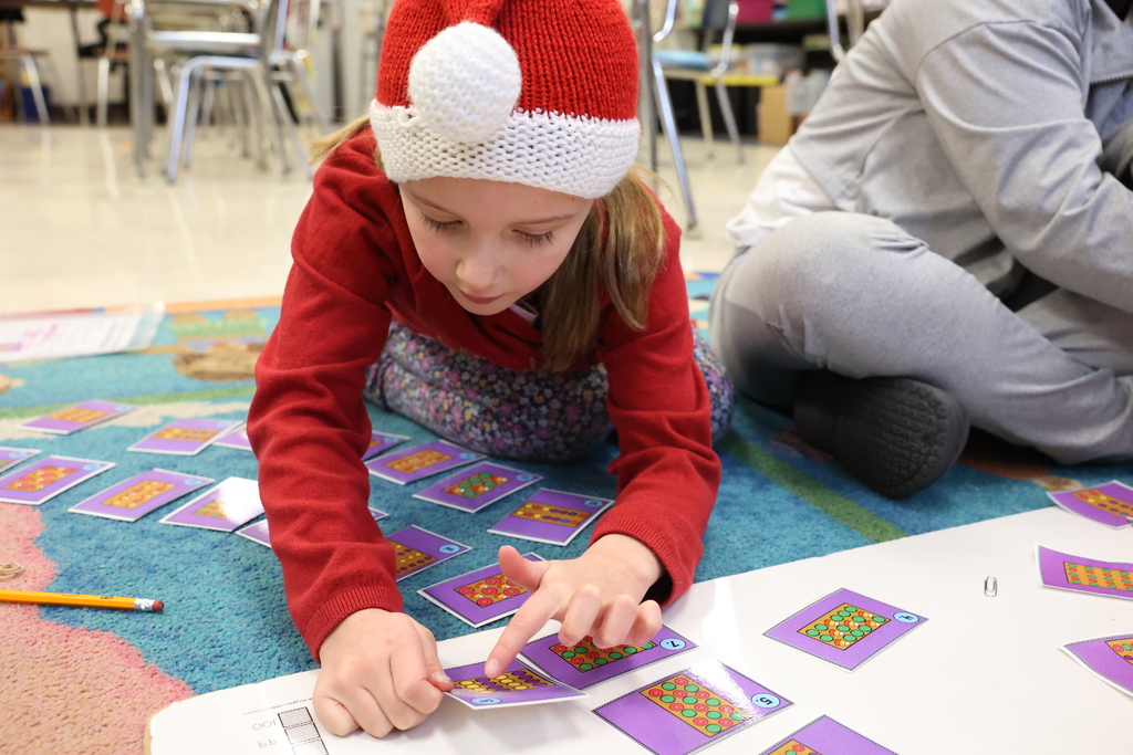 student counts cards on the floor