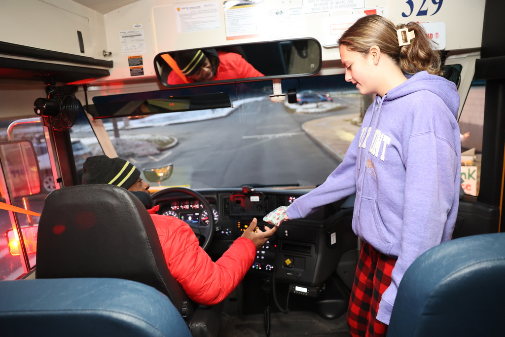 student hands bus driver a treat