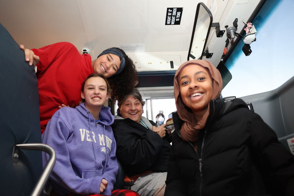 students smile with bus driver