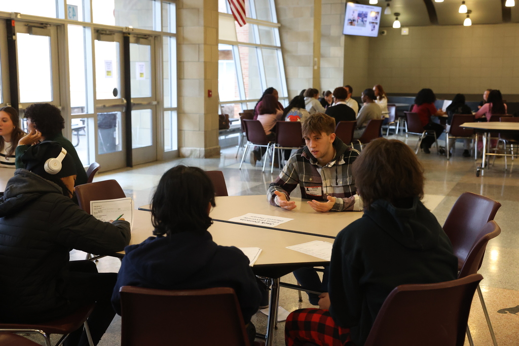 students sit at the table and listen to college student advice
