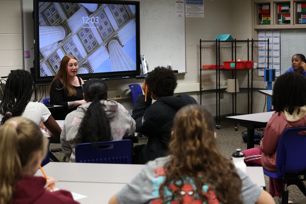 Students listen to guest speaker in the library