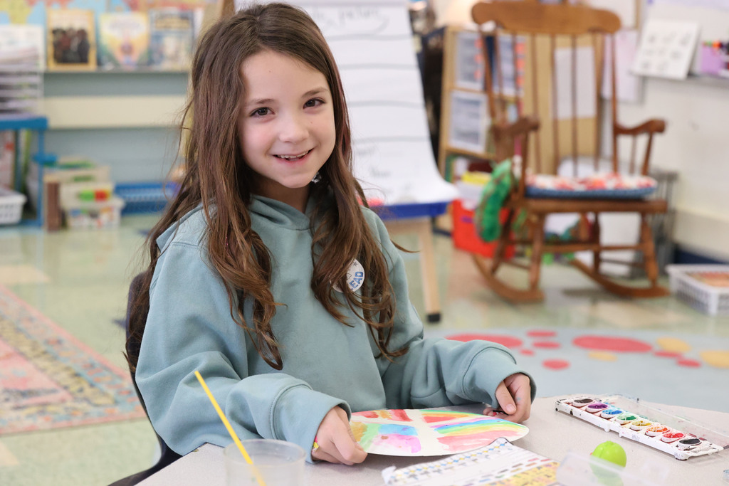 student smiles while painting