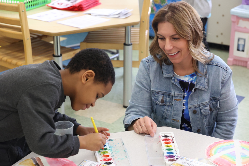 student paints with teacher