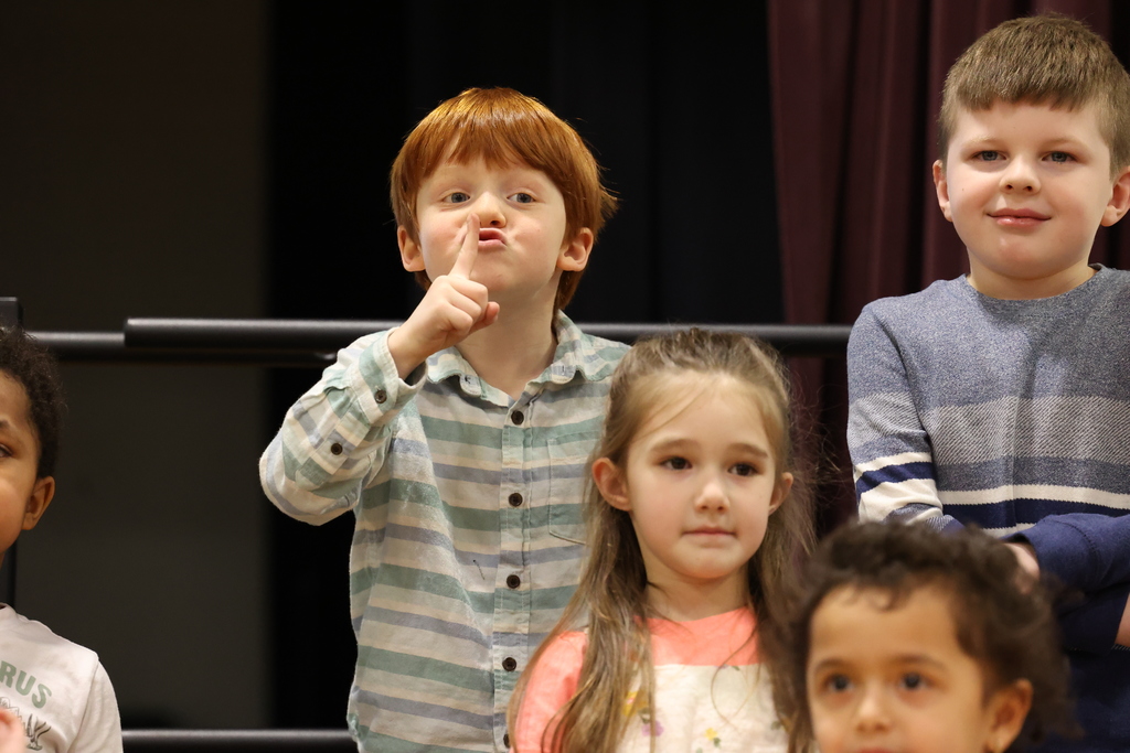 student holds up shh sign at winter concert
