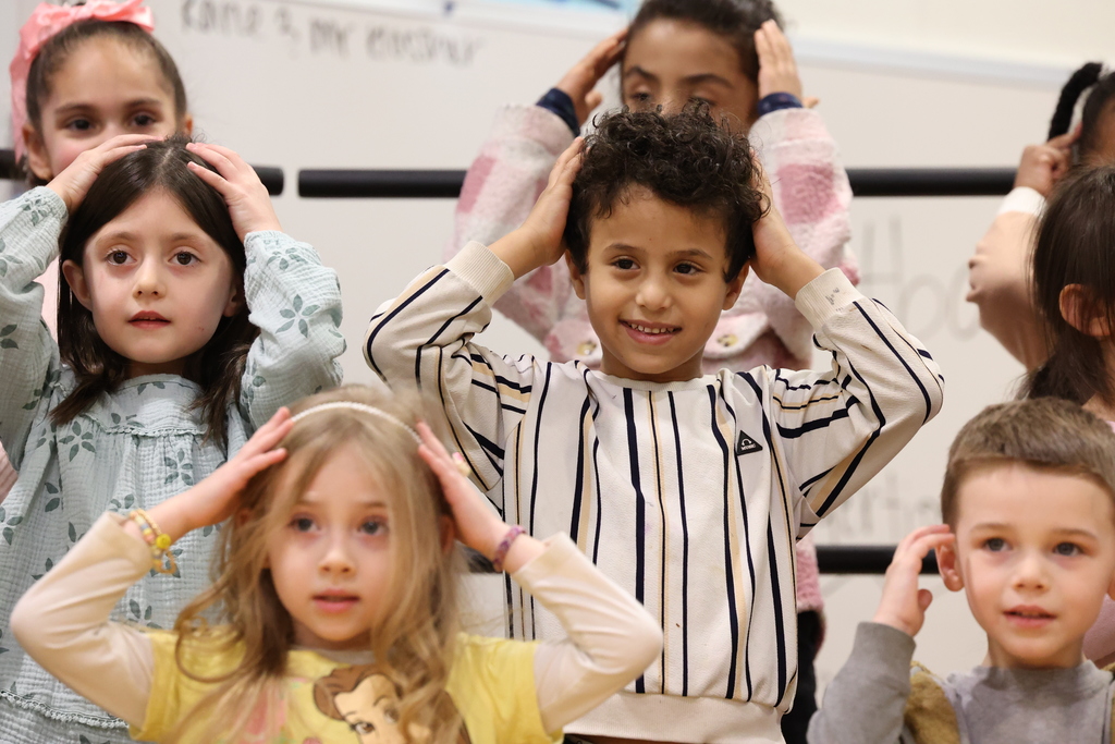 Students put hands on their head at a concert