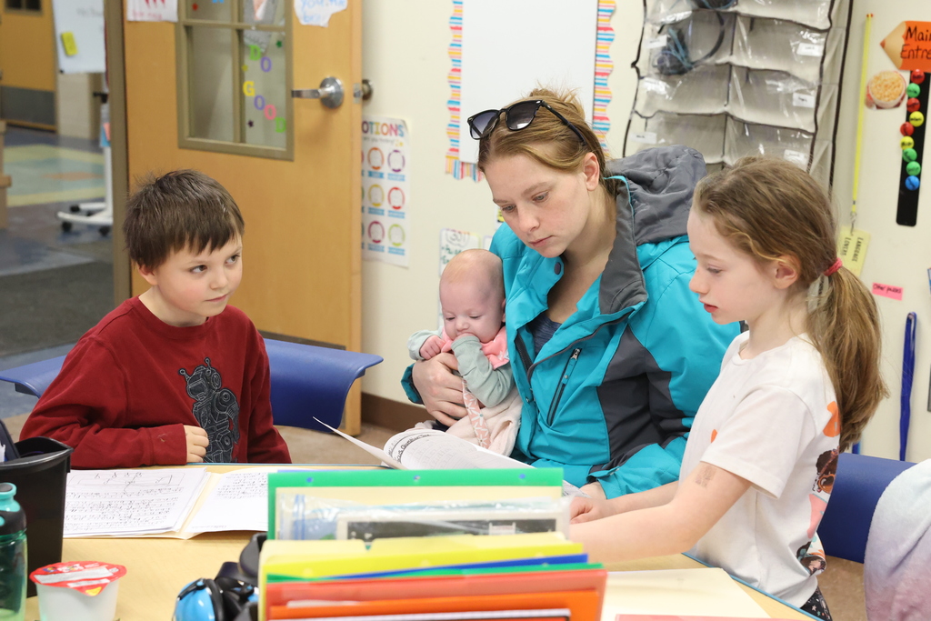student sits with parent and sibling while participating in poetry activity