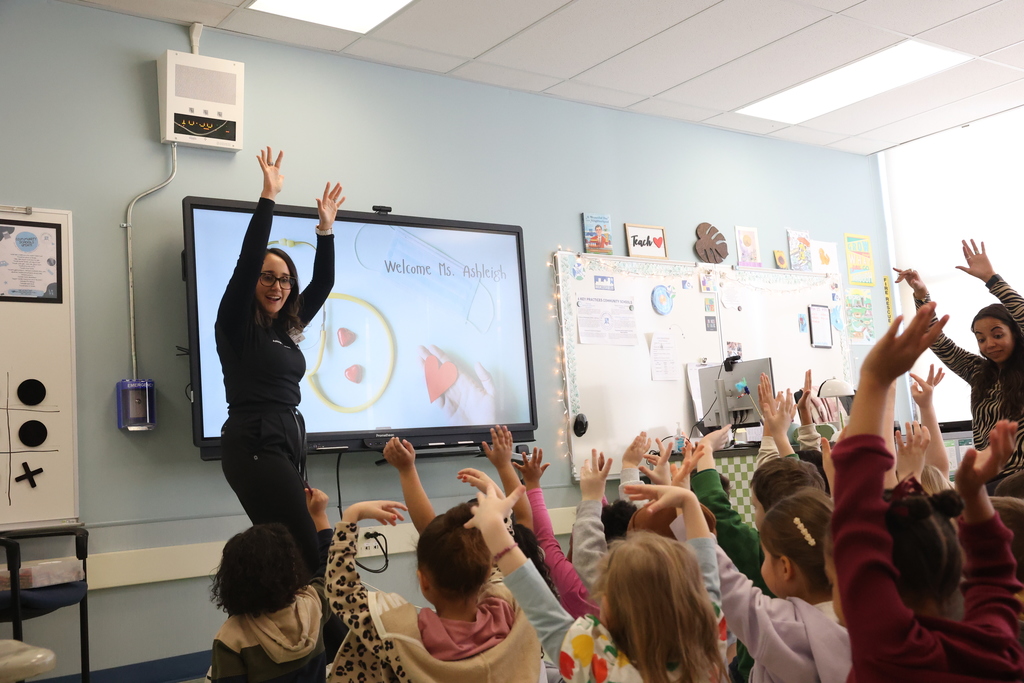 Students put their hands in the air with speaker