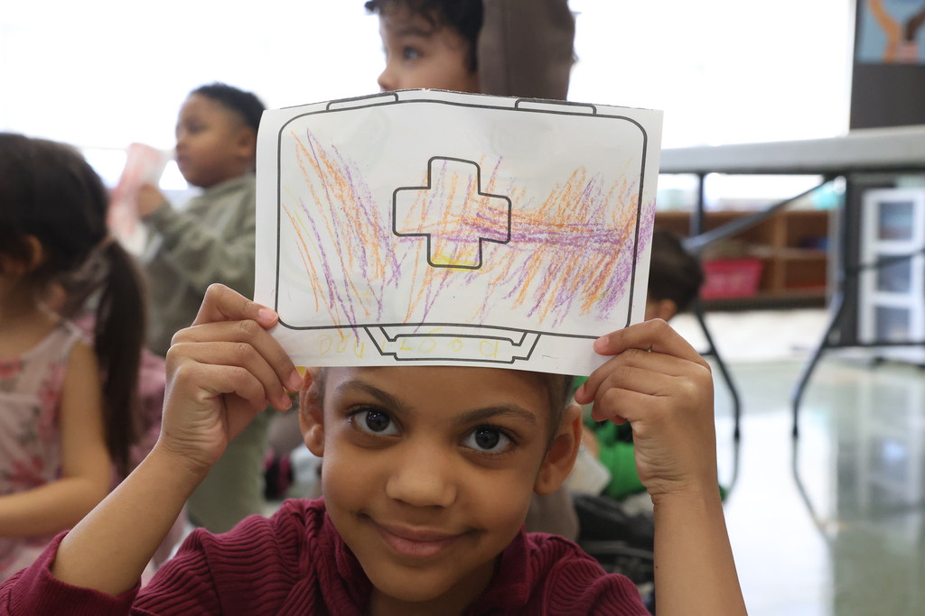 student holds up coloring 