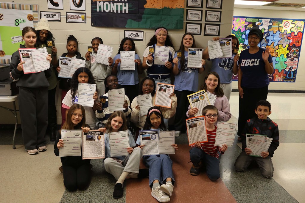 Students hold up worksheets